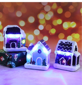 Detailed view of glowing Christmas resin house models with warm LED lights and faux snow