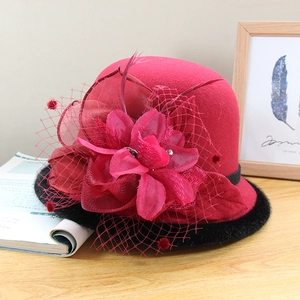 Close-up of red wool felt bucket hat with black faux fur trim and floral mesh detail