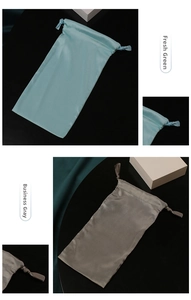 Detail of silk satin drawstring pouches in fresh green and business grey for jewelry