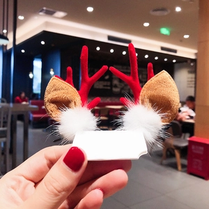 Close-up of Christmas hair clip with red reindeer antlers, brown ears and white faux fur