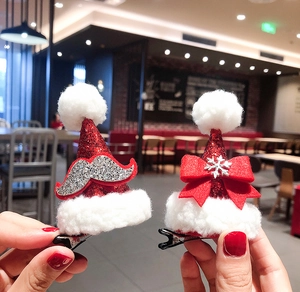 Close-up of glittery Christmas hat hair clips with festive reindeer and bow decorations