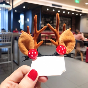 Detailed view of plush reindeer antler hair clips with small red mushroom accents