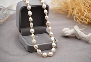 Elegant baroque freshwater pearl necklace displayed in a luxury grey velvet jewelry box