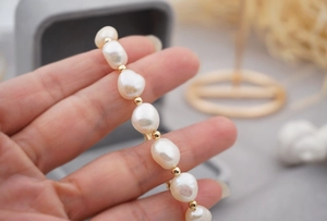 Macro shot of Baroque freshwater pearl bracelet with gold beads held in hand