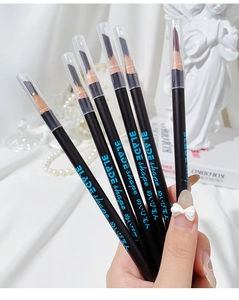 Detail view of blade-shaped wooden eyebrow pencils held against an elegant silk background