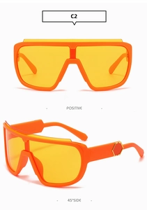 Detail view of large shield sunglasses in bright orange frame with yellow lenses
