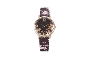 Close-up of rose gold watch dial with floral art and cherry blossom print leather strap