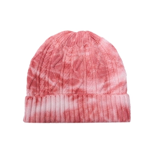 Detail of pink and white tie-dye cable knit beanie with a thick ribbed cuff texture