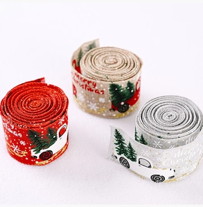 Close-up of three rolls of Christmas truck ribbons in red, grey, and natural linen textures
