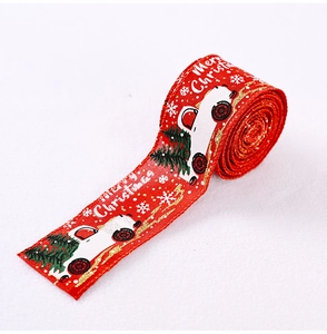 Detail of red Christmas ribbon featuring vintage truck, pine tree and snowflake patterns