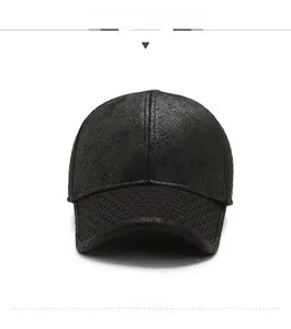 Detail of black baseball cap showing leather texture and grid embossed brim with metal logo