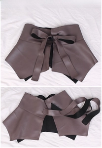 Detail of purple-brown PU leather corset belt with lace-up bow and ruffled hem