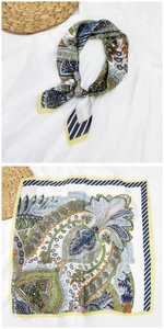 Dettaglio di un foulard quadrato in seta con motivi paisley etnici e bordo giallo