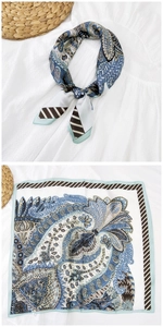 Dettaglio di un foulard in seta blu con motivo paisley e bordo geometrico elegante