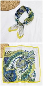 Dettaglio di un foulard in seta quadrato con motivi paisley in giallo, blu e verde