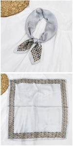 Dettaglio di un foulard quadrato in seta grigio argento con bordo a motivi geometrici