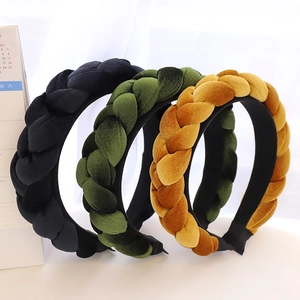 Detail of braided velvet headbands in black, olive green, and yellow with woven texture