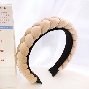 Macro detail of hand-woven beige velvet braided headband with soft texture and inner lining
