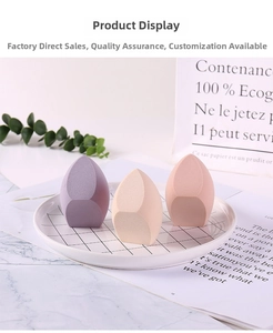 Gros plan d'éponges à maquillage sans latex violettes, beige et roses sur une assiette