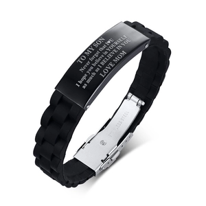Detail view of black silicone and stainless steel bracelet with engraved text for son