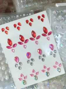 Detailed view of teardrop and olive-shaped multi-color rhinestone face and nail stickers