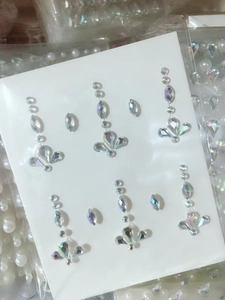 Detail of holographic rhinestone face stickers with teardrop and round gemstone patterns