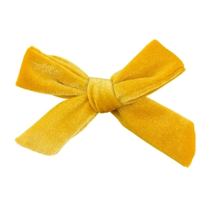 Macro detail of mustard yellow velvet handmade bow knot hair accessory with soft texture