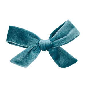 Detailed close-up of teal velvet bow hair accessory showing premium texture and fabric