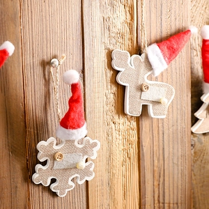 Christmas tree ornaments with reindeer and snowflake pendants on rustic wood background