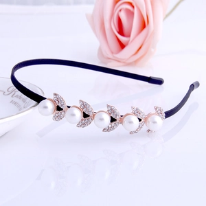 Detailed shot of gold metal headband featuring white pearls and rhinestone leaves