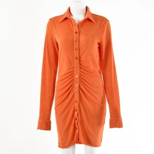 Detailed view of orange long sleeve mini dress with button closure and ruched waist