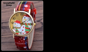 Detail of Christmas snowman watch dial with red plaid strap on a wooden surface
