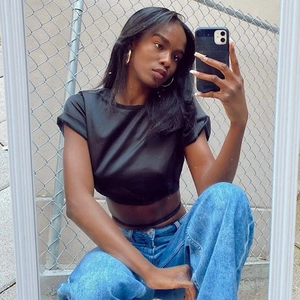 Outdoor mirror selfie of a black cropped short-sleeve top with lace-up back detail