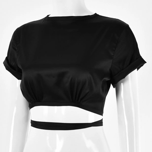 Detailed view of black satin crop top featuring a pleated hem and stylish waist tie details