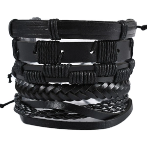 Close-up of five-piece set of black braided leather bracelets with mixed textures