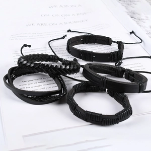 Detailed view of four black braided leather bracelets with adjustable sliding knots