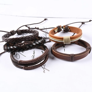 Close-up of four-piece set multi-layer braided leather bracelets in brown and black tones