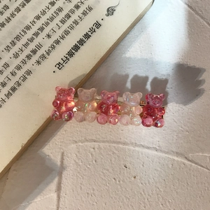 Detail of laser-effect resin bears with glitter on a golden metal duckbill hair clip