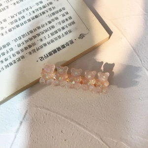 Detailed macro view of gold-tone hair clip with five shimmering pink resin bears