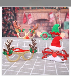 Detail of four festive Christmas glitter glasses with reindeer antlers and Santa hats