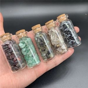 Macro view of five mini glass bottles with assorted natural healing crystal chips and corks