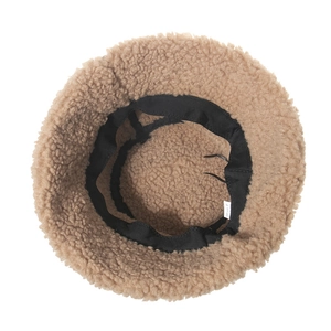 Vue intérieure du bob en peluche camel avec bandeau noir et détails de l'étiquette de soin
