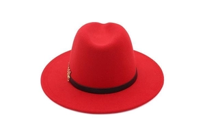 Detailed close-up of a red wool fedora hat with black band and gold leaf decoration