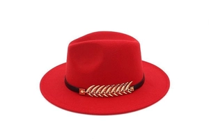 Detail of red wool felt fedora featuring a gold leaf metal trim and black band
