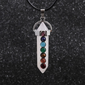 Macro shot of hexagonal white crystal chakra pendant with seven colored gemstones
