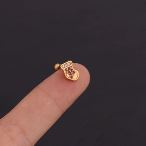 Puces d'oreilles botte de Noël dorées avec zircons rouges et blancs sur le bout du doigt