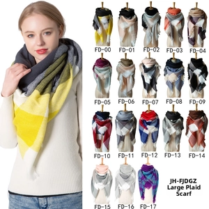Macro detail of soft cashmere-like large plaid scarf with fringe and various color patterns