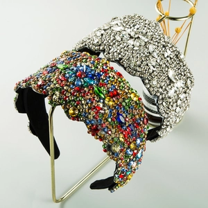 Detail of wide sparkling headbands featuring colorful crystals and a white rhinestone floral pattern