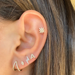 Close-up of 18k gold letter A earring and star studs with micro-pave cubic zirconia