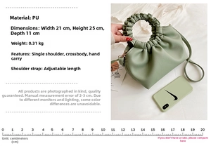 Detail view of light green pleated PU bag showing dimensions 21x25x11cm and adjustable strap